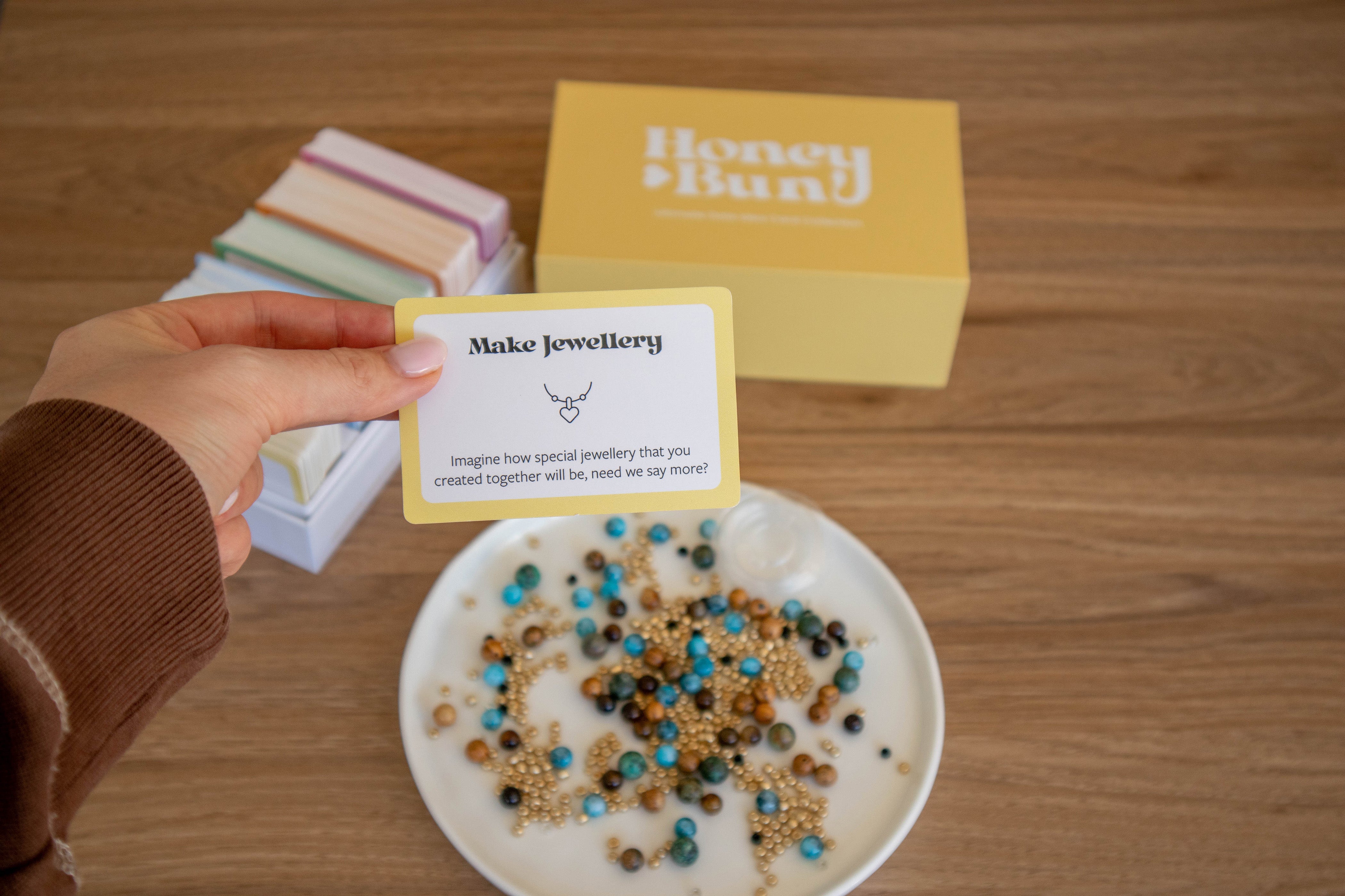 Girl holding a date idea card, at home date idea card, jewellery making date, making matching jewellery for couples, romantic and affordable date idea for couples, things to do when you're in a relationship