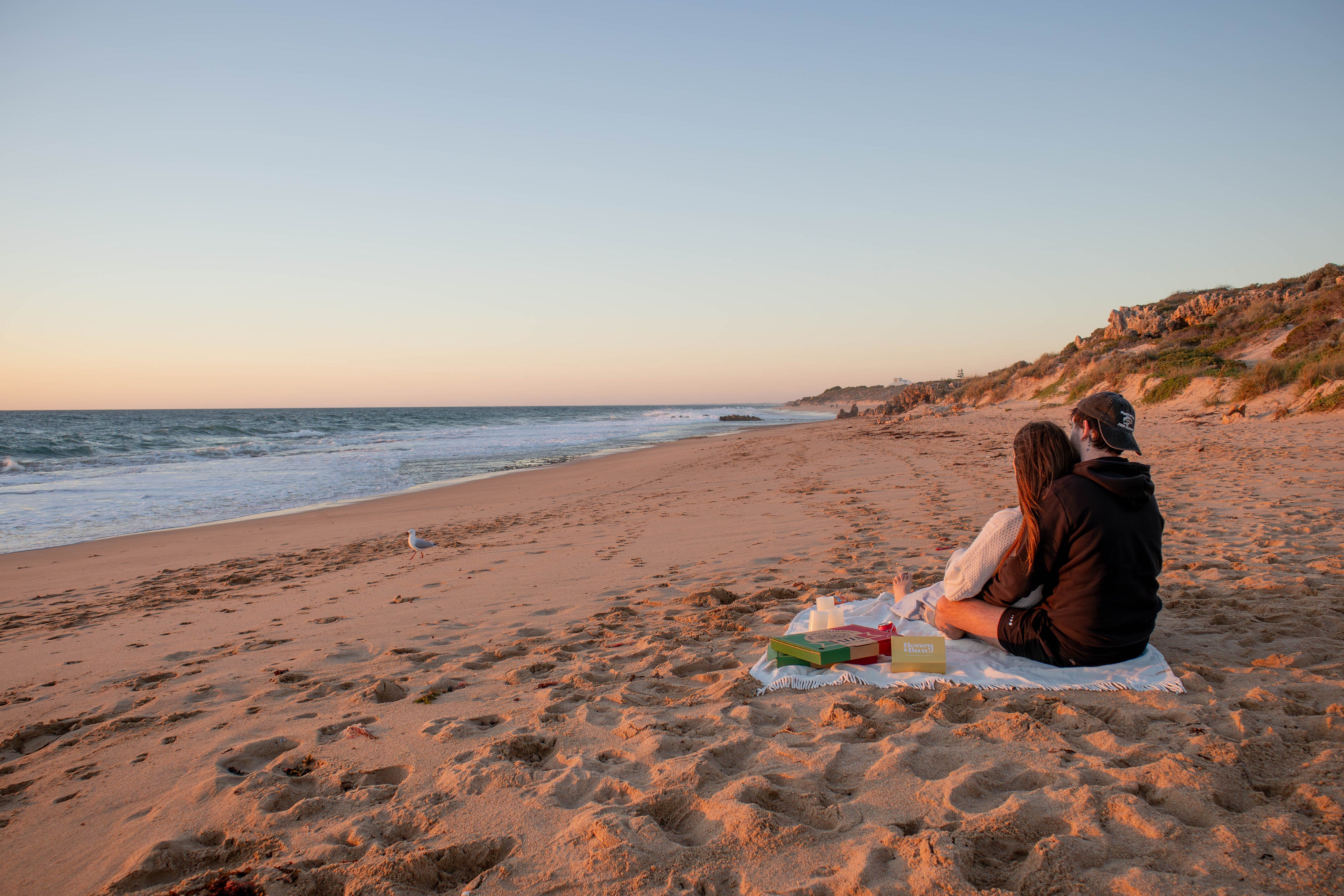 cute couple watching the sunset together, romantic beach sunset date, couple activities, eating pizza on the beach at sunset, date night ideas, dates to try when you're in a relationship, chill date ideas, date idea card box, sunset at the beach
